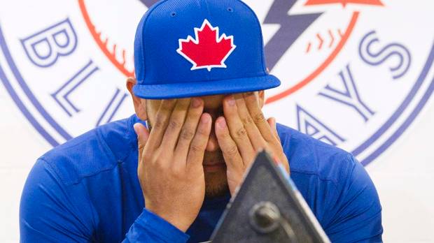 Melky Cabrera has his face in his hands before a Toronto Blue Jays spring training press conference.