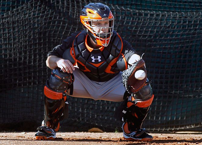 San Francisco Giants catcher Buster Posey crouches behind home plate during spring training drills.