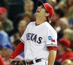 Mitch Moreland stands at first base with his glove on his hip, while he laughs.
