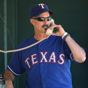 Mike Maddux is on the bullpen phone in the Texas Rangers dugout.