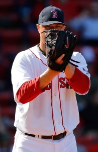 Boston Red Sox pitcher Jon Lester stares over his glove as he prepares to throw a pitch. 
