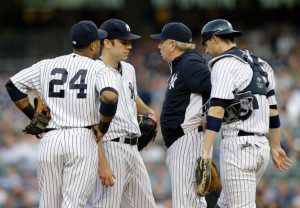 The replacement Yankees players and pitching coach meet on the mound.