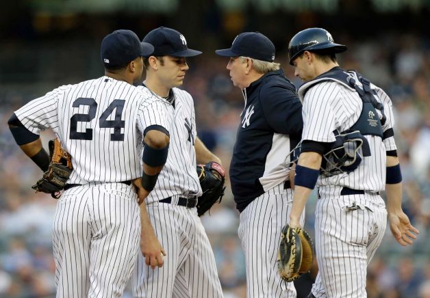 New York Yankees players and pitching coach meet on the mound.