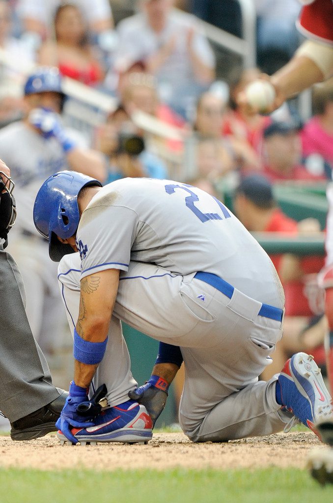 Matt Kemp grabs his ankle after sliding into home plate.