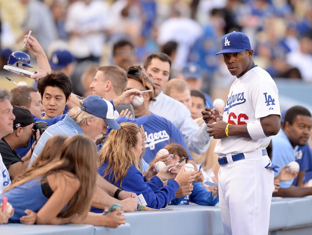 Yasiel Puig signs autographs before a game.