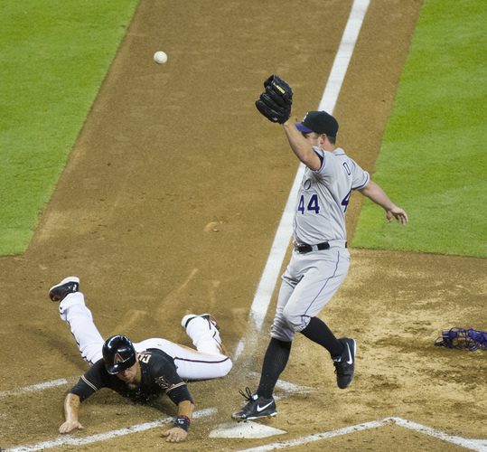 Roy Oswalt runs to cover home plate after a wild pitch.