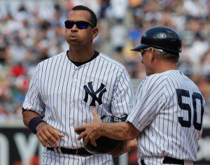 Alex Rodriguez exhales at the end of inning while handing his batting helmet to a coach.