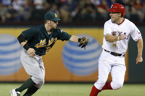 Oakland A's player chases a Texas Rangers player in a rundown.