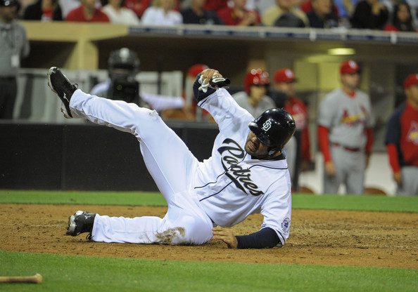 Carlos Quentin winces in pain on the ground after scoring a run