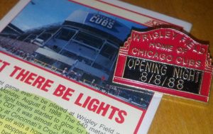 Picture of a pin commemorating the first game under the lights at Wrigley Field. 