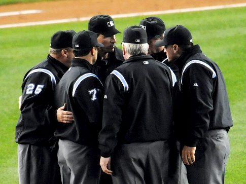 Umpire crew gathers to discus a call. MLB instant reply starts next season.